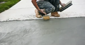 worker staining a concrete driveway to turn into decorative concrete